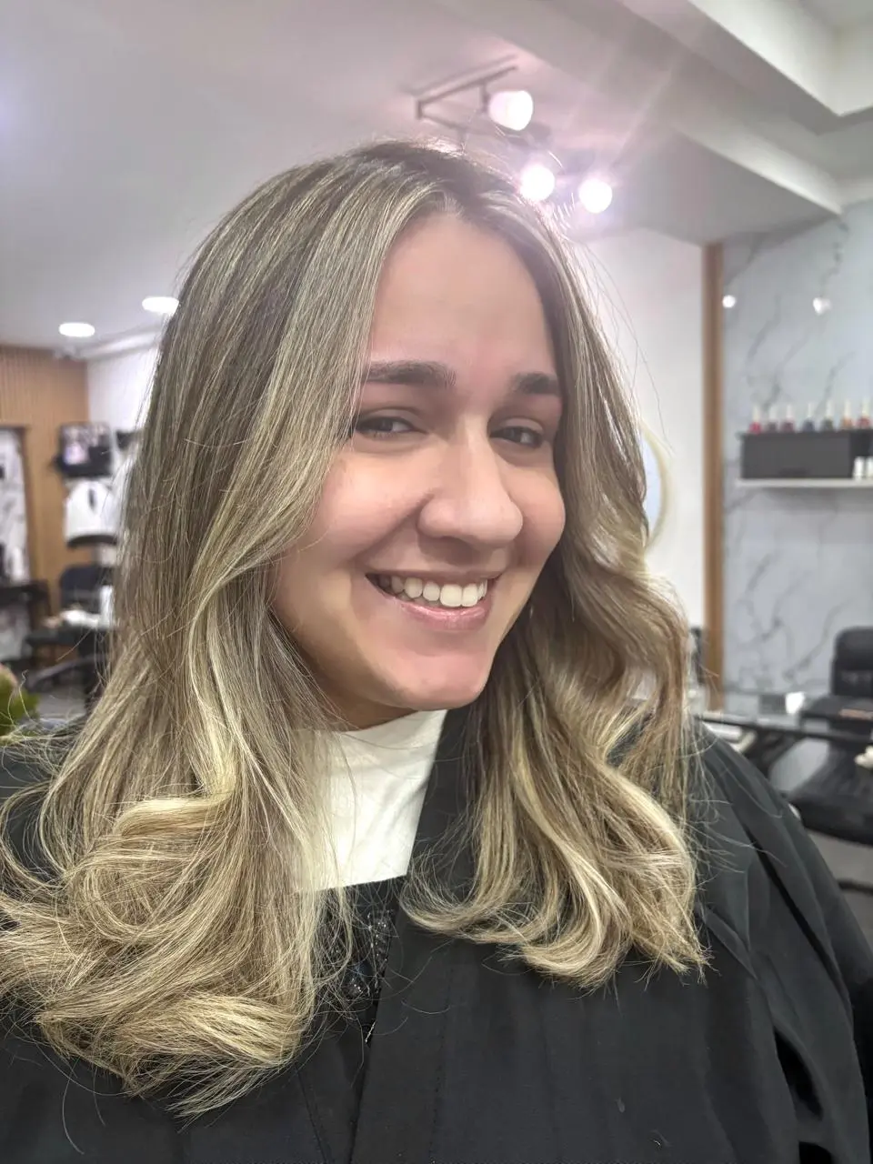 Cabello rubio cálido con raíz castaña y ondas, resultado de color de Balayage RD